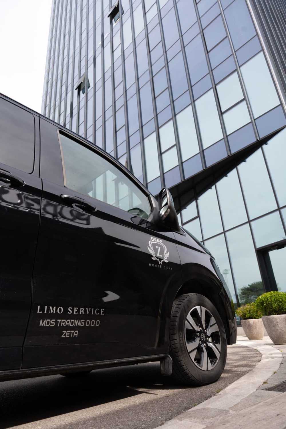 Monte Zeta crest and Limo Service lettering on the door of a black van